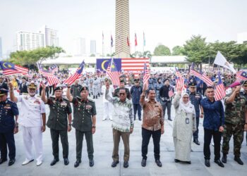 MOHAMED Khaled Nordin dan Malek Razak Sulaiman (empat, kiri) mengibarkan Jalur Gemilang bersama warga Kementerian Pertahanan pada Majlis Peluncuran Bulan Kebangsaan dan Kibarkan Jalur Gemilang di Wisma Pertahanan, Kuala Lumpur, semalam. – UTUSAN/MUHAMAD IQBAL ROSLI
