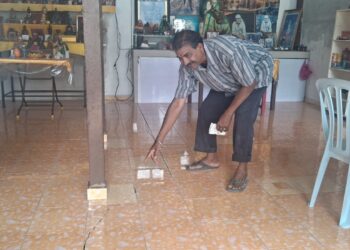 T. NADARAJAH menunjukkan keretakan pada lantai rumahnya yang didakwa antara kesan daripada aktiviti sebuah premis berhampiran kediamannya di Bentong, Pahang.