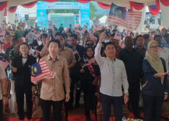 TEH Kok Lim (tengah) mengibarkan Jalur Gemilang ketika merasmikan Program Madani Kita di Dataran Warisan Taiping, hari ini.  UTUSAN/WAT KAMAL ABAS