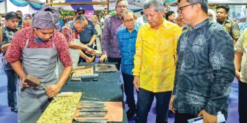 Shaharuddin Abu Sohot (dua dari kanan) melihat demonstrasi ukiran kayu selepas merasmikan Program Jelajah Mesra Festival Kraf Perak 2026 di Dataran Menara Condong, Teluk Intan, kelmarin.