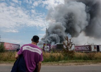 SEORANG pekerja melihat kepulan asap ketika kebakaran di kompleks logistik syarikat e-dagang Russia, Wildberries berhampiran bandar Podolsk di luar Moscow. - AFP