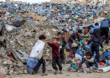KANAK-kanak mengasingkan barangan daripada timbunan sampah di kem pelarian Palestin Maghazi, tengah Gaza.- AFP