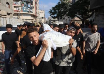 PENDUDUK  mengusung jenazah dari Hospital Al-Shifa menuju ke tanah perkuburan di Gaza kelmarin. - AFP