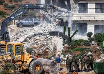 ASKAR Israel berkawal ketika jentolak merobohkan sebuah bangunan milik Palestin atas alasan tiada permit pembinaan di Qalandia, selatan Ramallah, Tebing Barat.- AFP