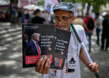 SEORANG lelaki menunjukkan poster yang memaparkan Presiden AS, Donald Trump, ketika menyertai protes membantah campur tangan AS ke atas Venezuela di Dataran El Vezezolano, Caracas.- AFP