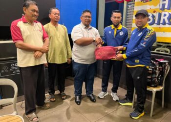 FIRDAUS Abd Razak melakukan penyerahan sumbangan buat pasukan sepak takraw Perlis kepada Mohd Masri Saidin pada majlis makan malam di Kangar, Perlis, semalam. -UTUSAN/ASYRAF MUHAMMAD