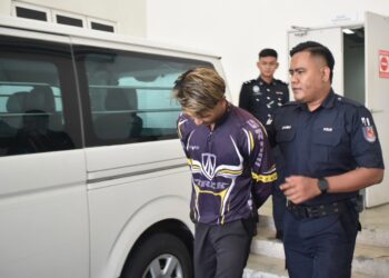 TERTUDUH (kiri) di bawa keluar dari Kompleks Mahkamah Kangar, Perlis, selepas menghadapi pertuduhan mengaibkan kehormatan dan mencuri pada Rabu lepas. -UTUSAN/ASYRAF MUHAMMAD