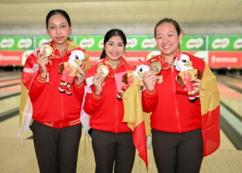 Gandingan Adania Mohd Redzwan (kiri) bersama Adelia Nur Irwan Syazalee  (tengah) dan Qurratu'ain Izdihar Mohamad Pozi mengumpul keseluruhan 3,560 jatuhan pin untuk menafikan cabaran Kedah yang terpaksa berpuas hati dengan perak menerusi 3,516 pin. - IHSAN MTBC