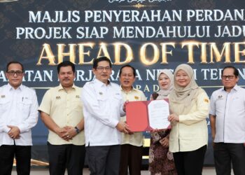 FADHLINA Sidek (tiga dari kanan) dan Ahmad Maslan (empat dari kiri) menyaksikan penyerahan dokumen pada Majlis Penyerahan Perdana Projek Siap Mendahului Jadual oleh Jabatan Kerja Raya Negeri Terengganu kepada Kementerian Pendidikan di SMK Tok Jembal, Kuala Nerus, Terengganu. – UTUSAN/PUQTRA HAIRRY