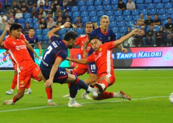 PENYERANG JDT,  Zaheditabar Shahab berjaya melakukan rembatan walaupun cuba dihalang pertahanan Kelantan Red Warrior FC pada aksi Liga Super di Stadium Sultan Ibrahim, Iskandar Puteri, kelmarin.-UTUSAN/RAJA JAAFAR ALI