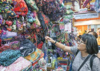 Pelancong asing tertarik dengan pelbagai hiasan dan cenderamata berasaskan batik yang terdapat 
di kedainya di Pasar Seni, Kuala Lumpur. – MINGGUAN/AMIR KHALID
