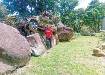 SYAZWAN Anas Abdul Mutalib bersama kereta Toyota Wish miliknya yang rosak semasa kejadian kepala air enam tahun lalu yang kini dijadikan monumen di belakang rumahnya di Salak Denai, Batu Hampar di Yan, Kedah.