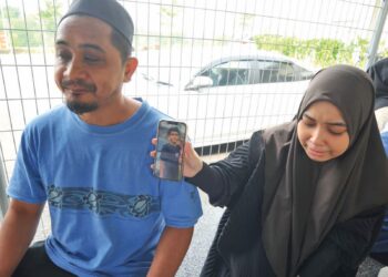 NUR Ain Natasya Mohamad Khairudi (kanan) menunjukkan gambar adiknya, Mohammad Haikal Ramzi di samping bapanya, Mohamad Khairudi Setapa di Jabatan Forensik, Hospital Pasir Gudang, Bandar 
Seri Alam, Johor Bahru. – UTUSAN/RAJA JAAFAR ALI