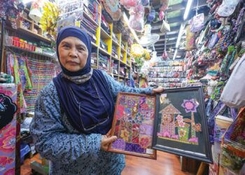 NOR FOUZIAH Yahaya menunjukkan antara batik yang dihasilkannya selama lebih empat dekad dan dijual di Pasar Seni, Kuala Lumpur.