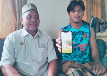 MOHAMAD Alif Ezzahan Zulkifli menunjukkan video kejadian petir di Sungai Golok Thailand ketika ditemui dirumahnya di Kampung Tujoh Tumpat, Kelantan semalam. – UTUSAN/ROHANA ISMAIL.