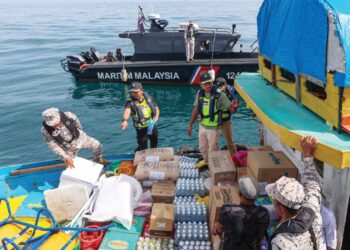 MOHD. Musfi Lat (dua dari kiri) bersama anggota KPDN Terengganu melakukan pemeriksaan ke atas resort dalam operasi penguatkuasaan bersepadu di Pulau Perhentian, Besut, Terengganu semalam.-UTUSAN/PUQTRA HAIRRY