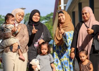 Pengundi, Nur Farahanim (kiri) bergambar bersama keluarga selepas menunaikan tanggungjawab pada proses pengundian sempena Pilihan Raya Negeri (PRN) Negeri Sembilan di IPG Raja Melewar Sikamat. -UTUSAN/ISKANDAR ISHAK