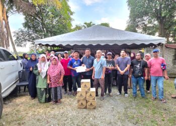 MOHD Nazari Sabran (tengah) menerima 84 borang keahlian baharu UMNO pada Majlis Perasmian Pasti Bersatu, Pas dan PKR di Parit 4C di Sungai Manik semalam. - UTUSAN/AIN SAFRE BIDIN
