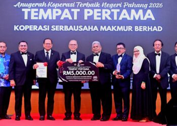 WAN ROSDY Wan Ismail (empat dari kiri) menyampaikan replika cek kepada wakil Koperasi Serbausaha Makmur Berhad (KOSMA) yang dinobatkan sebagai koperasi terbaik negeri Pahang pada Majlis Apresiasi Gerakan Koperasi Negeri Pahang di Kuantan, Pahang. - FOTO/SHAIKH AHMAD RAZIF