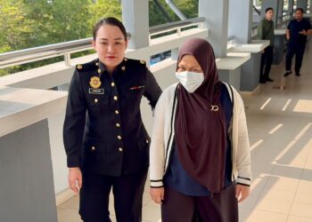 NORAINI Aripin yang diiringi pegawai Suruhanjaya Pencegahan Rasuah Malaysia (SPRM) dibawa ke Mahkamah Seremban atas pertuduhan melakukan pecah amanah membabitkan wang berjumlah RM6.55 juta milik syarikat. -UTUSAN / NOR SHAFIQAH MOHD. GHAZALI
