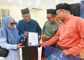 NORZAN Ahmad (dua dari kiri) menunjukkan sijil penganugerahan yang diterimanya kepada isteri dan dua anaknya selepas Majlis Sambutan Maulidur peringkat Negeri Pahang di Dewan Konvokesyen Sultan Haji Ahmad Shah di Pekan, Pahang. - FOTO/SHAIKH AHMAD RAZIF