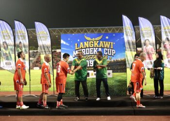 MUHAMMAD Sanusi Md Nor bersama Zuraidi Rahim menyampaikan hadiah kepada pemain Singapura yang menjuarai Langkawi Merdeka Cup Nostalgia 1993 di Stadium Langkawi. - UTUSAN/ SHAHIR NOORDIN