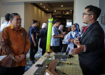 MOHAMAD Radzi Abdul Talib (kiri) melawat rerurai pameran selepas menyempurnakan Majlis Perasmian Simposium Bah Monsun (SIMBAH) 2026 di Bangi, semalam. - UTUSAN/MUHAMAD IQBAL ROSLI