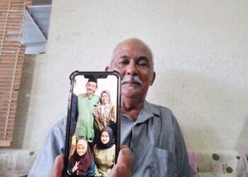 MOHD. Nadzri Razali menunjukkan gambar keluarga Shaik Mohd. Firdaus yang terkorban dalam nahas jalan raya di Jalan Sultan Ismail, Kuala Lumpur, semalam.