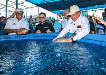 MOHAMAD Sabu melepaskan ikan ke dalam kolam ketika melawat lokasi tarikan sempena persediaan menjelang Pameran Pertanian, Hortikultur dan Agropelancongan Malaysia (MAHA) 2026 di MAEPS Serdang di sini, hari ini. - UTUSAN/SYAKIR RADIN