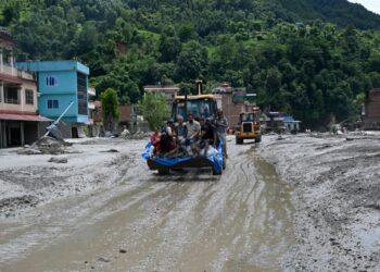 ANGGOTA penyelamat mengangkut penduduk yang terkandas menggunakan sebuah jentolak selepas banjir kilat melanda kawasan Devighat di daerah Nuwakot, Nepal, Rabu lalu. - AFP.