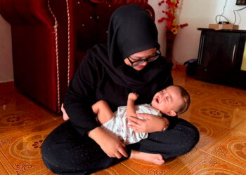 NURUL Najwa Nabila memangku Nayla Ameena Mohd. Azamirrizan 
di Felda Lepar Hilir 1 di Kuantan, Pahang.