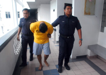 SYED Khairul Anwar Syed Jaafar dibawa keluar dari Mahkamah Sesyen Ayer Keroh.-UTUSAN/AMRAN MULUP