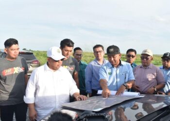 ABU Bakar Hamzah (dua dari kiri) melihat pelan pembinaan litar permotoran di kawasan Perindustrian Lembah Industri Chuping (CVIA), Padang Besar, Perlis semalam. -UTUSAN/ASYRAF MUHAMMAD