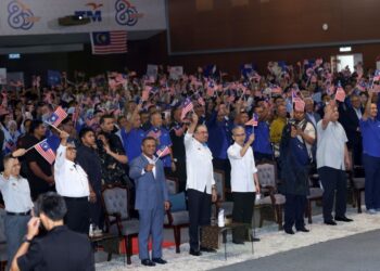 ANWAR Ibrahim mengibarkan Jalur Gemilang pada Majlis Peluncuran Sambutan Ulang Tahun Ke-80 TM di Dewan Tunku Canselor, Universiti Multimedia (MMU), Cyberjaya, semalam.-UTUSAN/FAISOL MUSTAFA