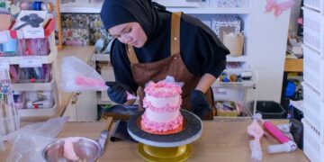 TENGKU Nurul Iman Alianna Tengku Ali Sha menghias kek ketika ditemui di premisnya, baru-baru ini. UTUSAN/M. FIRDAUS M. JOHARI
