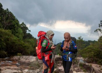 NOOR Azura Abdul Wahab (kiri) dan Nor Hayati Hamzah sewaktu di puncak Gunung Chemerong, Hulu Dungun, Dungun, Terengganu. 

– MINGGUAN/PUQTRA HAIRRY