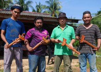 MOHD. Rudi Jusof (dua dari kanan), Rosdi Abd. Hamid (kanan) dan Abd. Mutalib Abdullah (dua dari kiri) menunjukkan sebahagian keris yang dihasilkan di Kampung Beris Lampu, Besut, Terengganu. -UTUSAN/PUQTRA HAIRRY