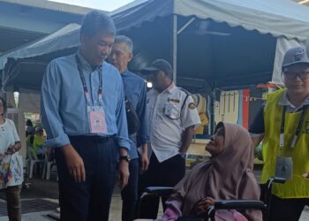 MOHAMAD Hasan beramah mesra bersama penduduk ketika tiba di tempat mengundi, di sini hari ini.