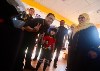 AEDY Fadly Ramli bergambar bersama seorang kanak-kanak yang menerima topi keledar sempena Peluncuran Kampung Angkat MADANI dan Sekolah Angkat MADANI di Sekolah Kebangsaan Titi Gajah di Alor Setar.