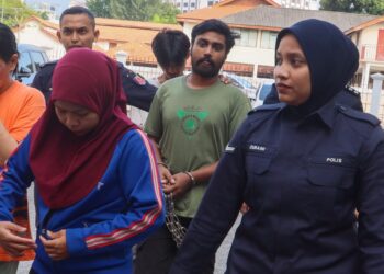 SANY (dua dari kanan) bersama teman wanitanya, Dina Hayati (depan, kiri) dihadapkan ke Mahkamah Majistret George Town, Pulau Pinang hari ini atas pertuduhan membunuh seorang kanak-kanak lelaki berusia lima tahun, bulan lepas.-UTUSAN/DANIAL SAAD