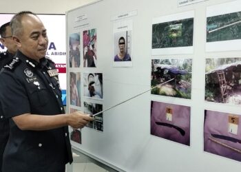 Mohd. Alwi Zainal Abidin (kanan) menunjukkan parang yang digunakan suspek untuk menyerang anggota polis ketika cubaan tangkapan di Batu Kurau semalam. – Foto Wat Kamal Abas