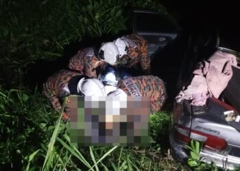 ANGGOTA bomba membantu membawa keluar mangsa yang maut selepas kereta dipandunya terbabas masuk ke dalam longkang di Kilometer 42, Kampung Pulau Juar, Kampung Gajah semalam.
