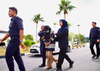 SITI Zulaika Ahmad Sabri dikawal anggota polis selepas mengaku bersalah kerana menganjurkan kumpulan wang kutu semasa pertuduhan di Mahkamah Sesyen Alor Setar, hari ini. - UTUSAN/ SHAHIR NOORDIN