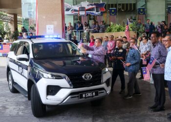 ANTHONY Loke meletakkan bendera Jalur Gemilang pada aset kenderaan MOT pada Majlis Perhimpunan Bulanan dan Majlis Pelancaran Bulan Kebangsaan Kementerian Pengangkutan Tahun 2026 di Putrajaya.- UTUSAN/FAISOL MUSTAFA