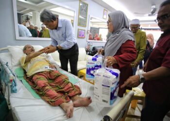 MOHAMAD Hasan melawat pesakit lumpuh dan saraf, Ahmad Khairul Anuar Mohd Zabidi, di Taman Pinggiran Senawang pada Program Ziarah Kasih.-UTUSAN/MOHD SHAHJEHAN MAAMIN.