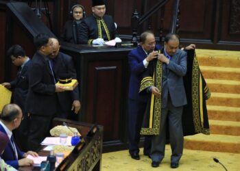ISMAIL Lasim menyarungkan jubah kepada  Awaludin yang dilantik sebagai Yang Dipertua DUN Negeri Sembilan yang baharu.--UTUSAN/MOHD. SHAHJEHAN MAAMIN