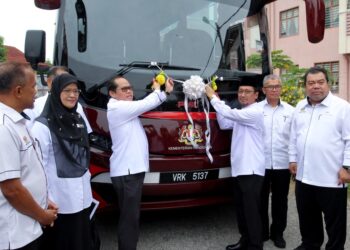 MOHD. Azam Ahmad (kiri) memotong riben sebagai gimik perasmian dan penyerahan bas untuk kegunaan pelajar dan warga Sekolah Menengah Kebangsaan Agama (SMKA) Naim Lilbanat, Kota Bharu, Kelantan hari ini-UTUSAN/KAMARUL BISMI KAMARUZAMAN