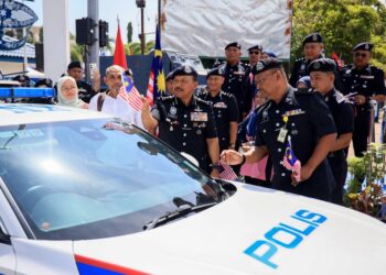 MOHD. Yusoff Mamat (kiri) memasang Jalur Gemilang selepas merasmikan Aktiviti Riadah Bermotosikal dan Sumbangan Kebajikan Polis Diraja Malaysia (PDRM) Bersama Ipoh Super Biker’s Club (ISBC) Sempena Sambutan Hari Polis dan Sambutan Ambang Kemerdekaan ke-69 di Kota Bharu, Kelantan hari ini-UTUSAN/KAMARUL BISMI KAMARUZAMAN.