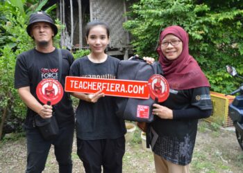 LOVELY Sabana Augustine (tengah) semasa menerima sumbangan komputer riba di rumahnya di Kampung Cenderung, Teluk Jering, Tumpat, Kelantan semalam.