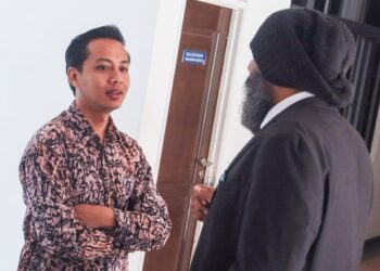 FAHMI Zainol (kiri) berbual bersama peguamnya, Dr. Shamser Singh Thind ketika hadir ke Kompleks Mahkamah Balik Pulau, Pulau Pinang, hari ini.-UTUSAN/DANIAL SAAD